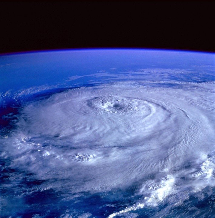 Satellite view of Hurricane Beryl forming over the ocean, with swirling clouds and a distinct eye at the center.